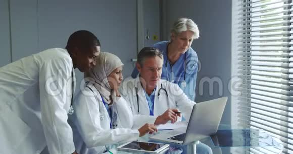 多民族医生在医院讨论笔记本电脑的正面看法视频的预览图