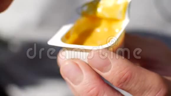 一个男人用芥末酱浸炸薯条调味酱和土豆罐的特写视频的预览图