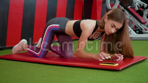 年轻女孩做腹肌练习有一个平坦的腹部美丽的肌肉女人在健身房做木板锻炼以改善视频的预览图
