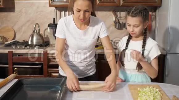妈妈和她十几岁的女儿正在厨房里一起做苹果派视频的预览图