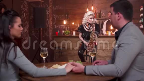 女音乐家为一对夫妇在餐馆里表演浪漫歌曲视频的预览图