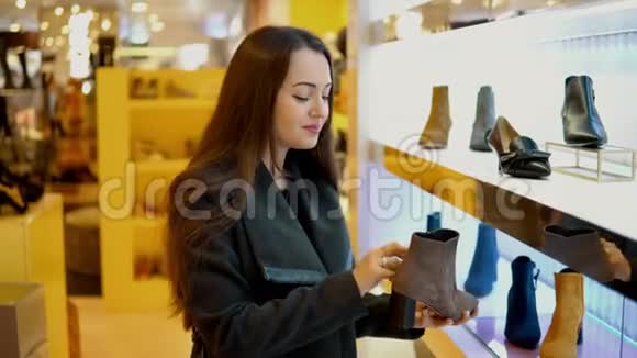 年轻漂亮的女顾客在商店超市里挑选女人靴子视频的预览图