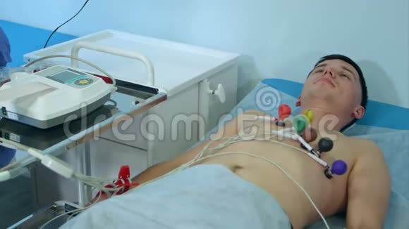 带心电图设备的护士在医院门诊对男性病人做心电图检查视频的预览图