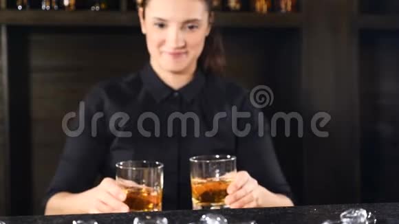夜总会里的夜生活女酒吧员把酒精鸡尾酒放在酒吧柜台的酒杯里酒吧和鸡尾酒概念视频的预览图