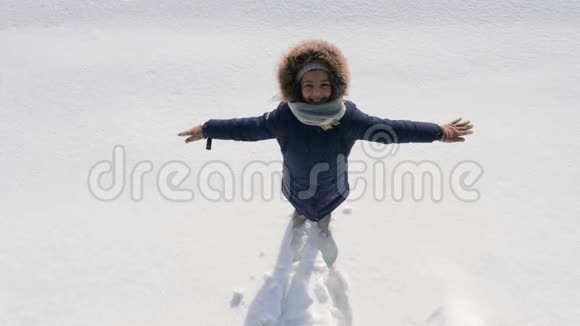 一个做雪天使的女孩的俯视图视频的预览图