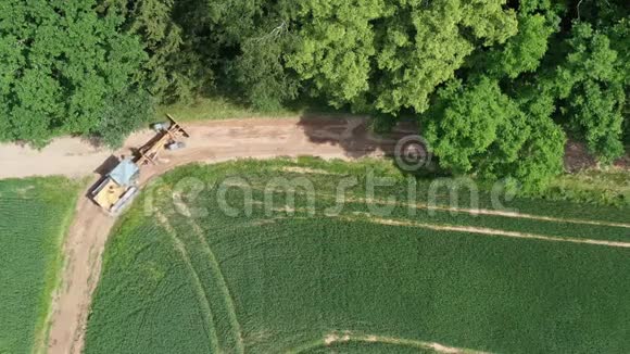 在恶劣的农场道路上进行道路平整的机动平地机空中视频的预览图