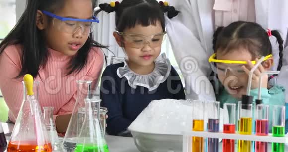 科学老师和亚洲学生看着一个冒泡的碗视频的预览图