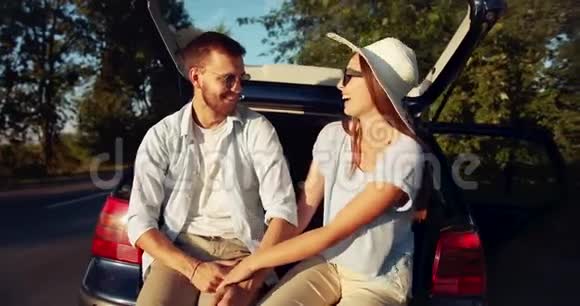 日落时分坐在车里的情侣视频的预览图