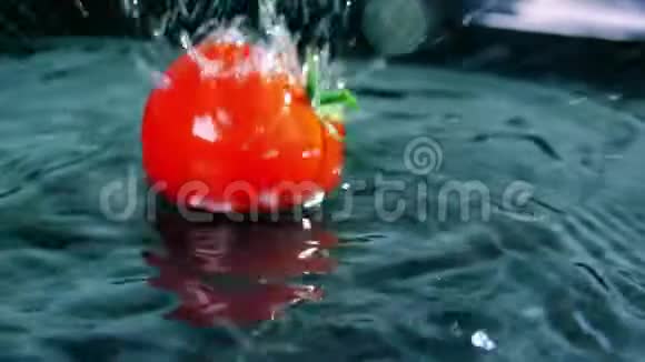 新鲜的红西红柿溅起水来慢镜头视频的预览图