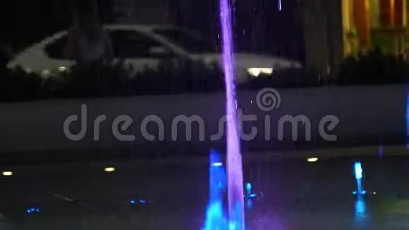 水射流随着灯光从地上冲出夜晚的城市喷泉视频的预览图