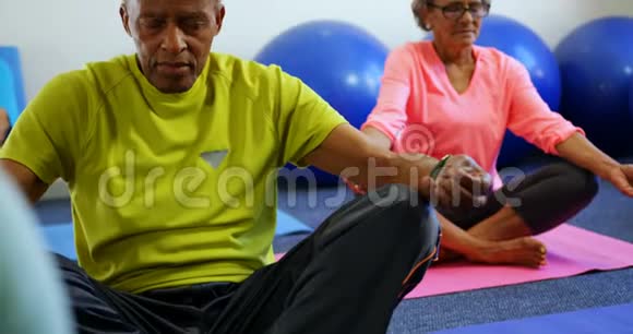 积极参与混合种族活动的老年人在健身工作室4k表演瑜伽的正面视图视频的预览图