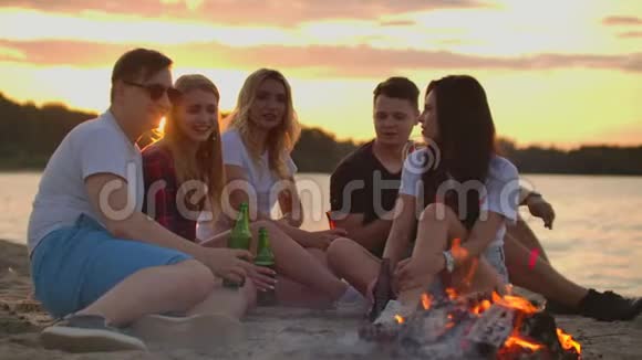 年轻人正在沙滩上享受温暖的夏日夜晚视频的预览图