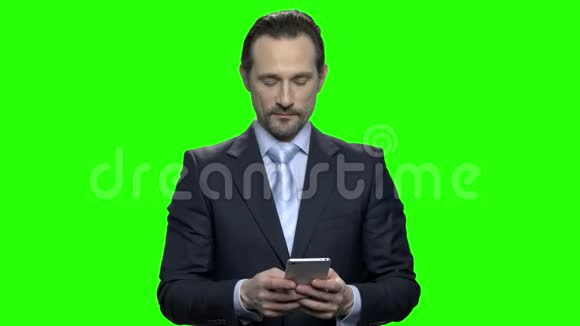 自信成熟的男人穿着黑色西装在智能手机上打字视频的预览图