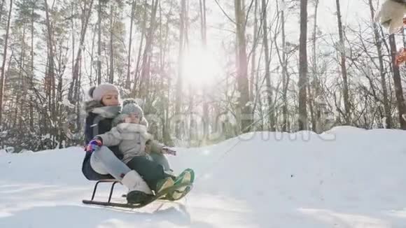 无法辨认的母亲拉着雪橇和孩子视频的预览图
