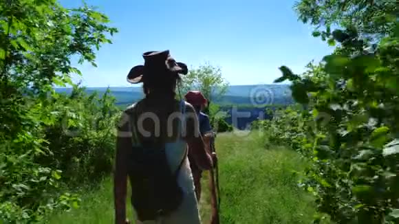 两个女旅行者女朋友在一个高原上走出森林视频的预览图