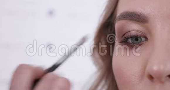 在一家美容院拍摄的一只年轻女子蓝眼睛特写镜头视频的预览图