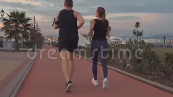 晚上男女运动员在公园区慢跑后景视频的预览图