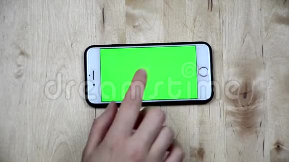 擦拭智能手机屏幕顶视图用手指触摸手机绿色屏幕阿尔法频道手机屏幕视频的预览图