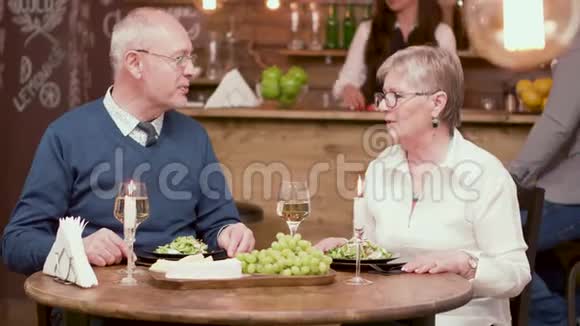 老人在浪漫的晚餐上为他的约会对象献花视频的预览图