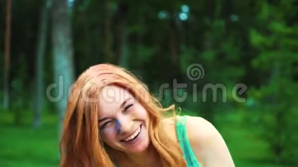 霍莉笑着看镜头后红头发的年轻女人闻到了五颜六色的粉末视频的预览图