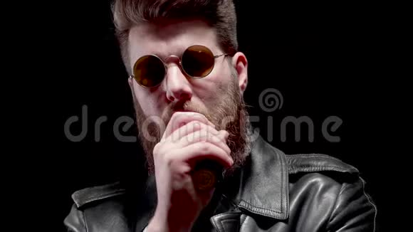 穿着皮夹克和时髦太阳镜的男人用白烟遮住镜框视频的预览图