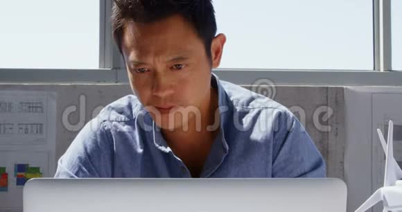 亚洲男性建筑师使用笔记本电脑在一个现代化的办公室4k视频的预览图