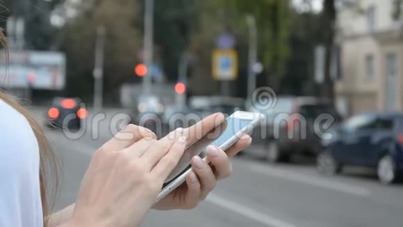 女性用手机和手机在城市道路附近打出租车视频的预览图