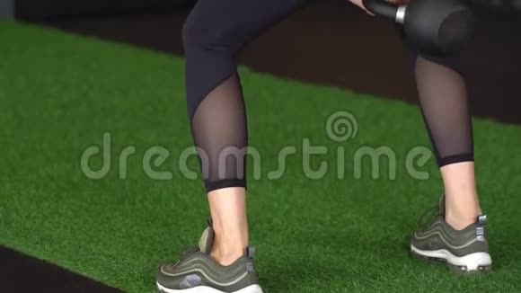 漂亮的运动女人用水壶铃做蹲享受锻炼肌肉男在健身房做交叉健身运动视频的预览图