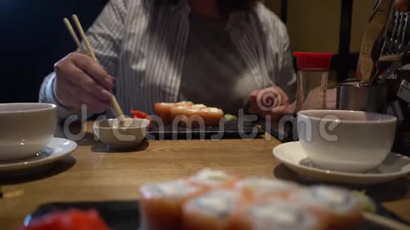 女人用木筷子吃寿司特写镜头中国筷子吃寿司卷视频的预览图