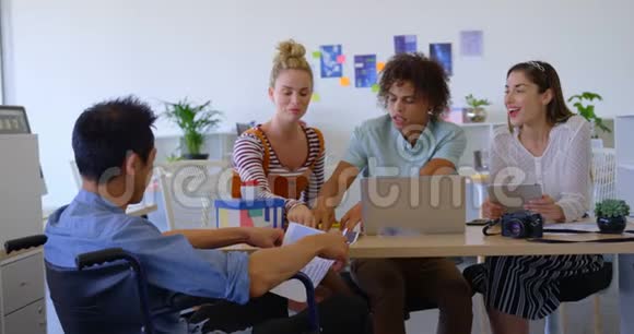 一位年轻的亚洲商人坐在椅子上与其他人讨论生意时的后视镜视频的预览图