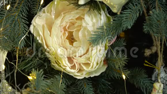 一棵用闪烁的灯光和一朵大的白花装饰的圣诞树视频的预览图