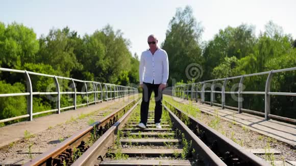 一个人从远处走在一座废弃的铁路桥上蹲在他身上全速射击视频的预览图