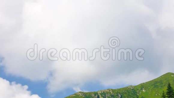 蓝天背景下白云带着青草飞过高山视频的预览图