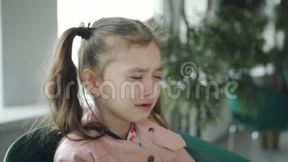 在窗边的咖啡馆里哭得心烦意乱的小女孩视频的预览图