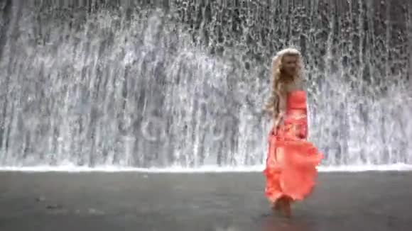 站在大瀑布背景下的年轻美女视频的预览图