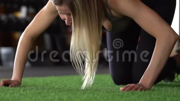运动美女做俯卧撑作为她的交叉健身健美体操训练常规的一部分慢动作视频的预览图