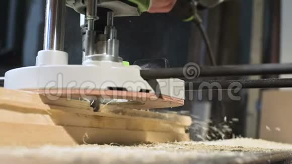 木工在家庭车间用手动电动切割机进行手工操作的手缓慢整理木制零件视频的预览图