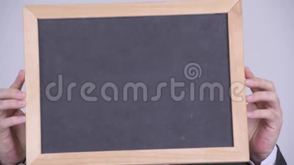 一张英俊的商人的脸展示着黑板和惊讶的表情视频的预览图