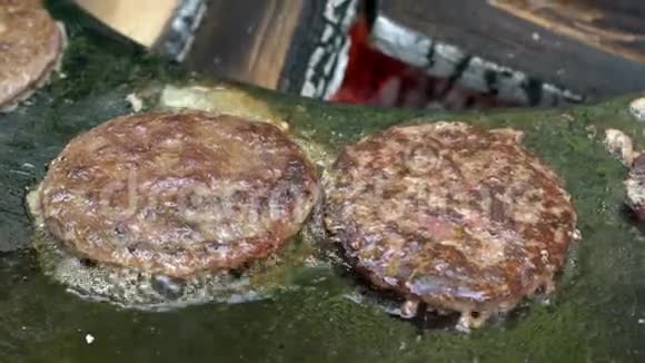 在铁板上炸汉堡肉在背景上烧柴火视频的预览图