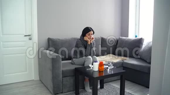 悲伤的单身女人坐在沙发上面前有很多药丸视频的预览图