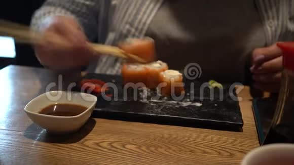 女人用木筷子吃寿司特写镜头中国筷子吃寿司卷视频的预览图