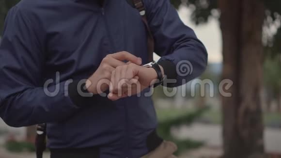 在户外人们正在控制他的智能手表他的手特写视频的预览图
