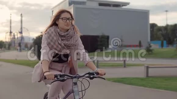 快乐的少年女孩正在黄昏的公园里骑自行车视频的预览图