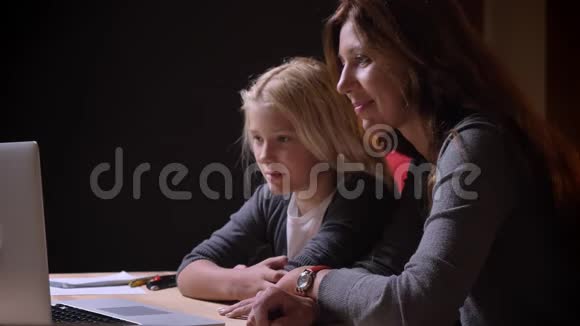 年轻白种人母亲和小漂亮女儿一起看电影的特写镜头妈妈抱着一个女孩视频的预览图