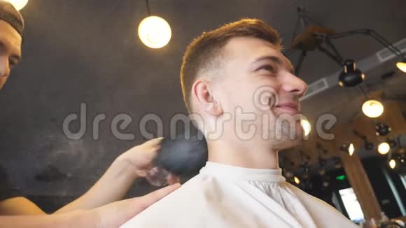 理发师用刷子清洗理发店理发的客户男理发师在年轻人脖子上用滑石粉视频的预览图