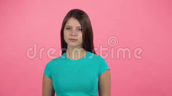 年轻的女性在粉红背景的工作室里笑慢动作视频的预览图