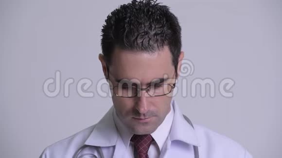 英俊的男医生摘下眼镜看着相机视频的预览图