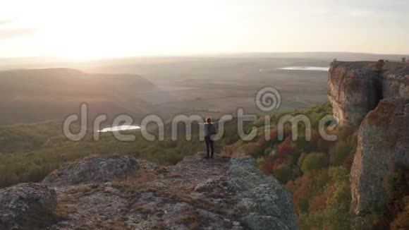 日落时分妇女在风景如画的岩层中徒步旅行视频的预览图