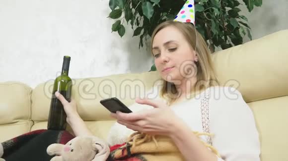 这个女孩独自在家庆祝节日喝酒用电话视频的预览图