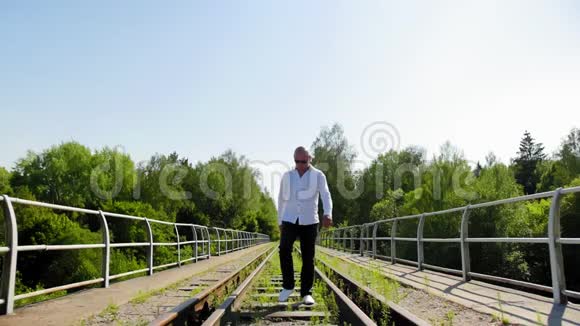 一个从远处走在废弃的铁路桥上的人慢动作全垒打视频的预览图